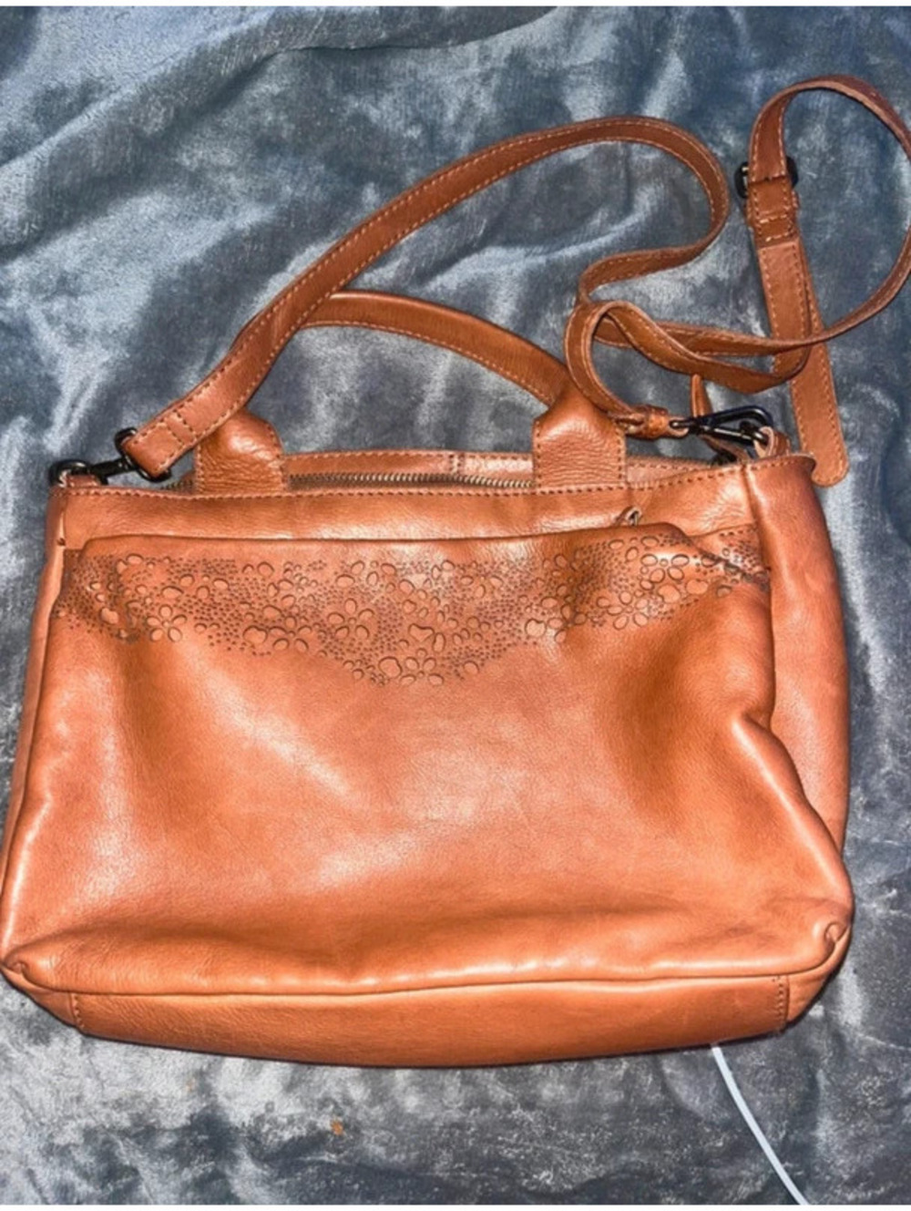 Tan leather crossbody bag with adjustable straps and multiple pockets